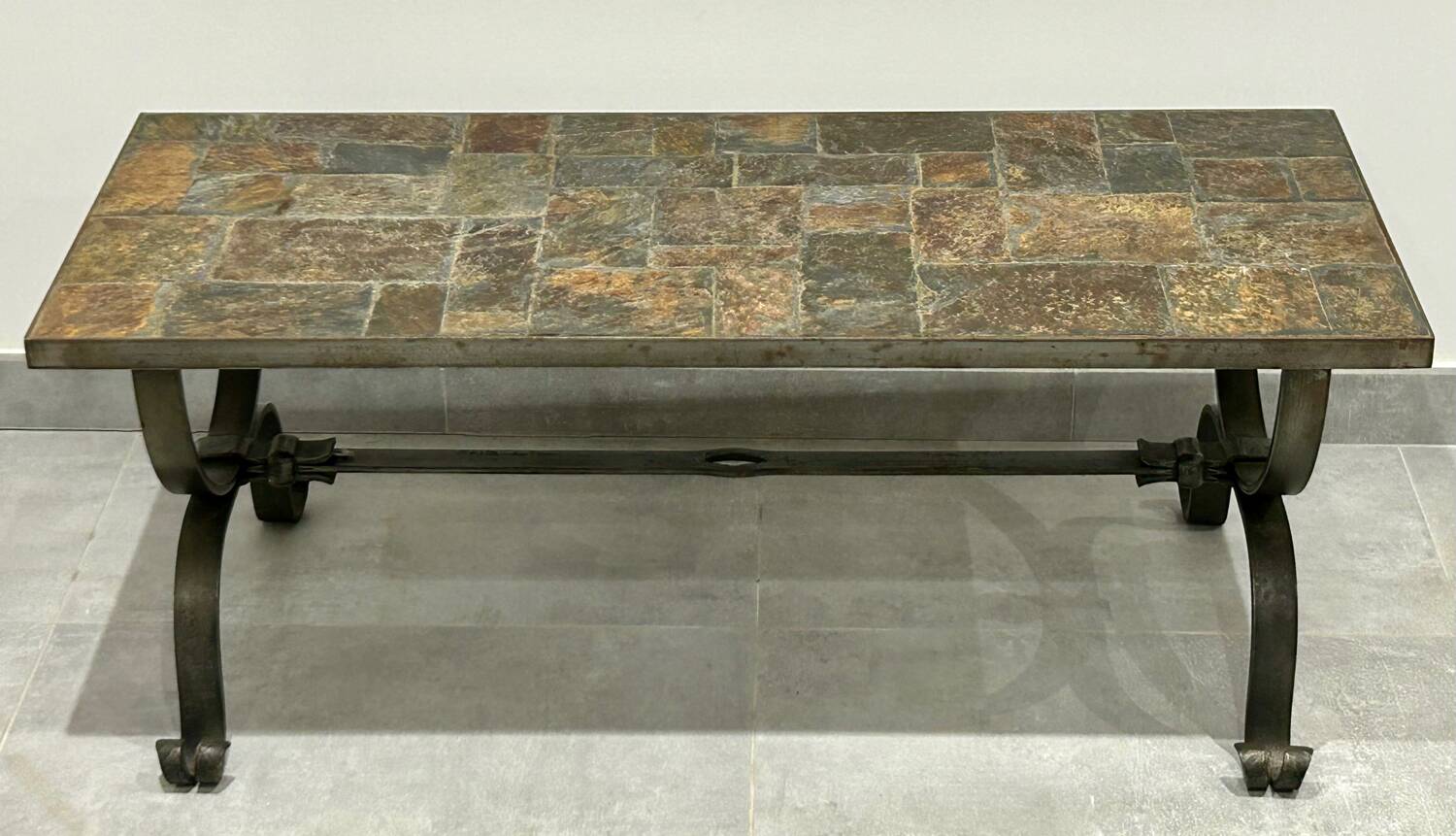 Brutalist-style coffee table made of mixed wrought iron and stone.