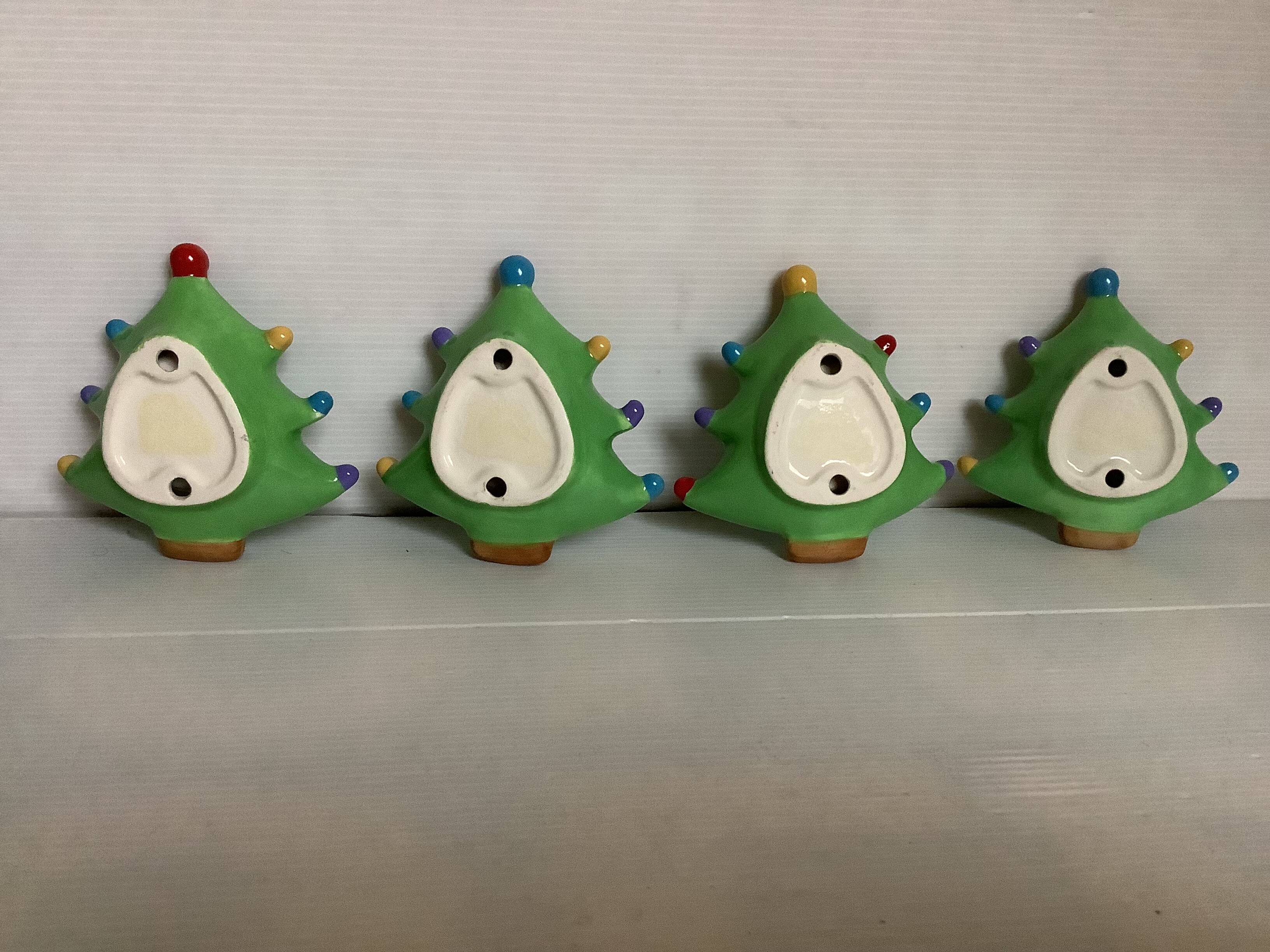 Four Christmas tree-shaped candle holders