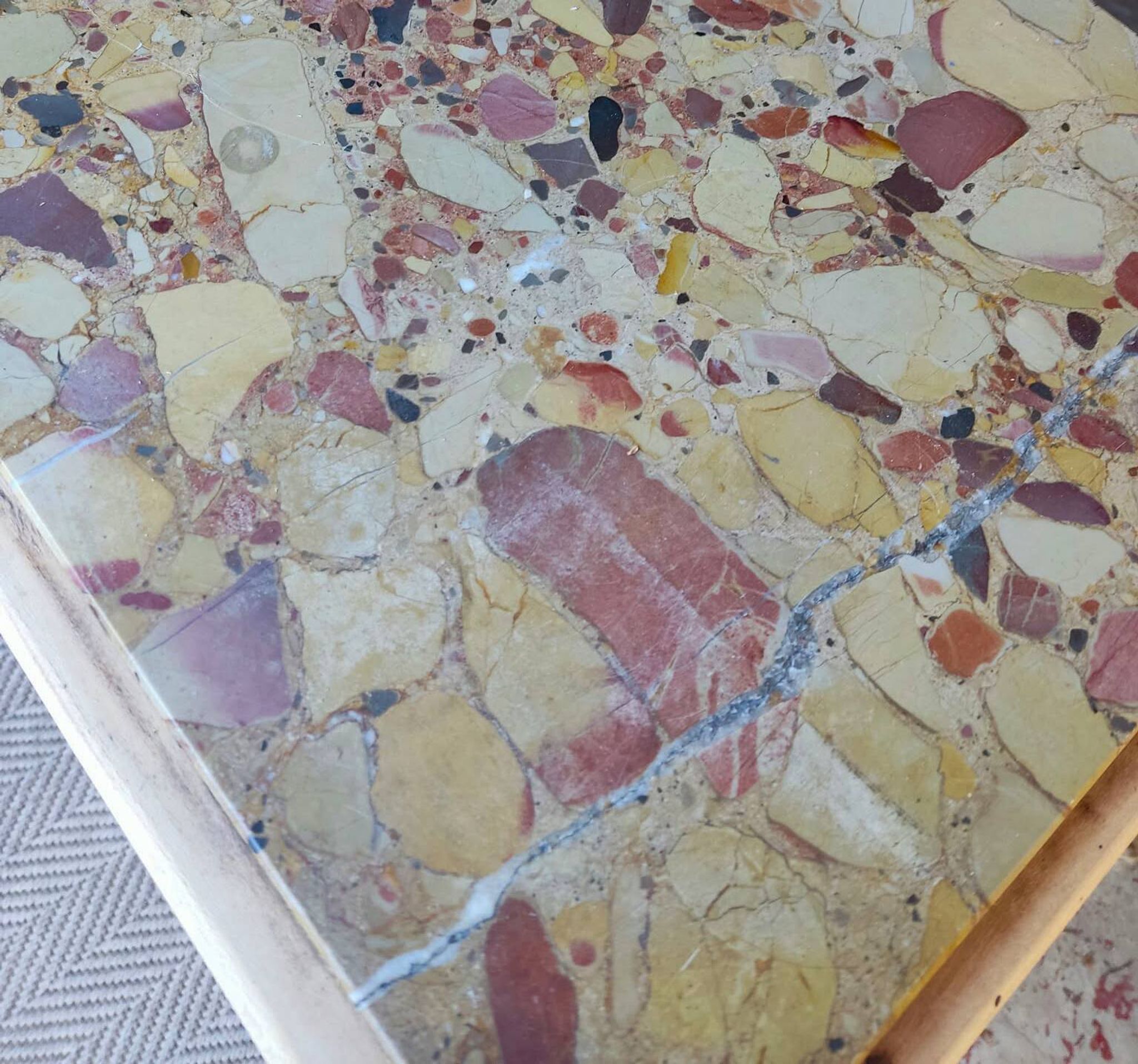 Small Art Deco bedside table in light wood with a terrazzo effect top.