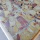 Small Art Deco bedside table in light wood with a terrazzo effect top.