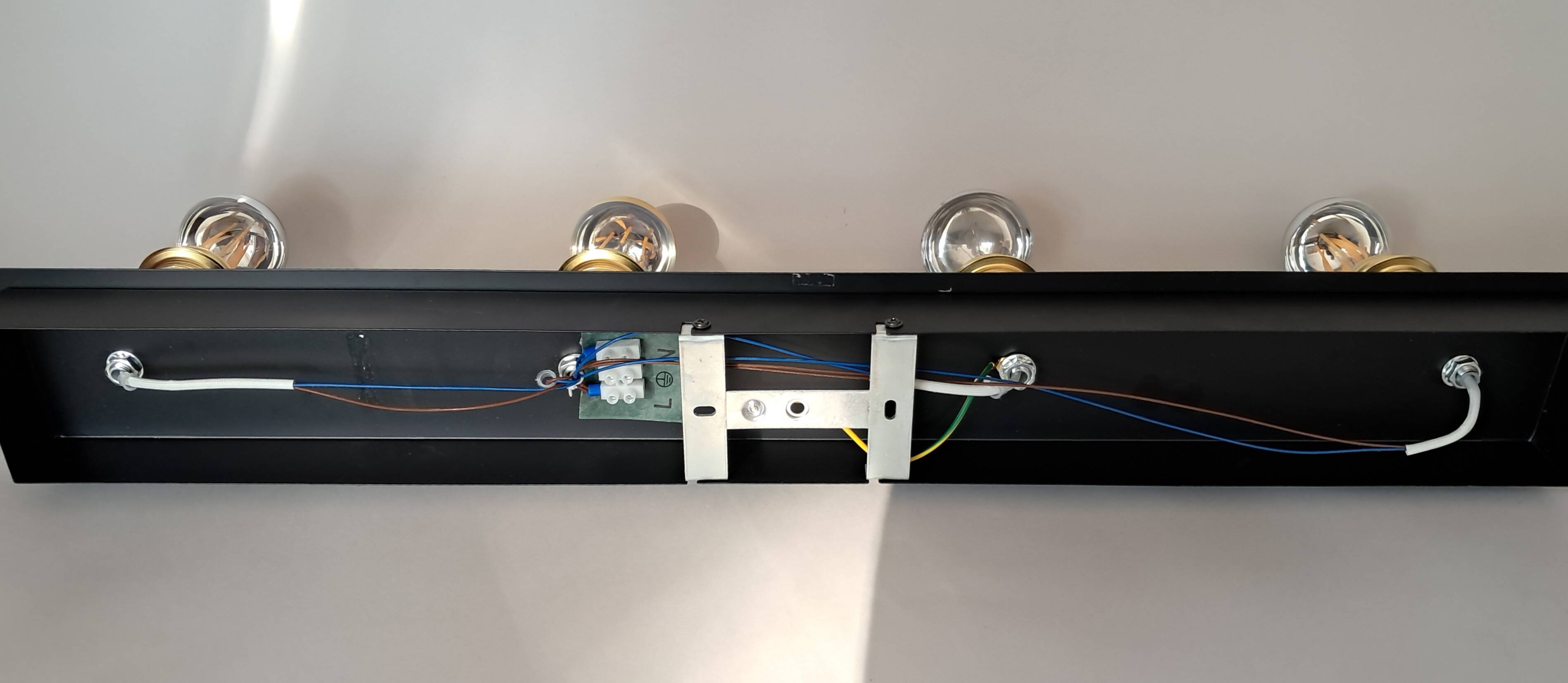 Wall lamp with 4 adjustable lights in black metal and gold-plated brass sockets.