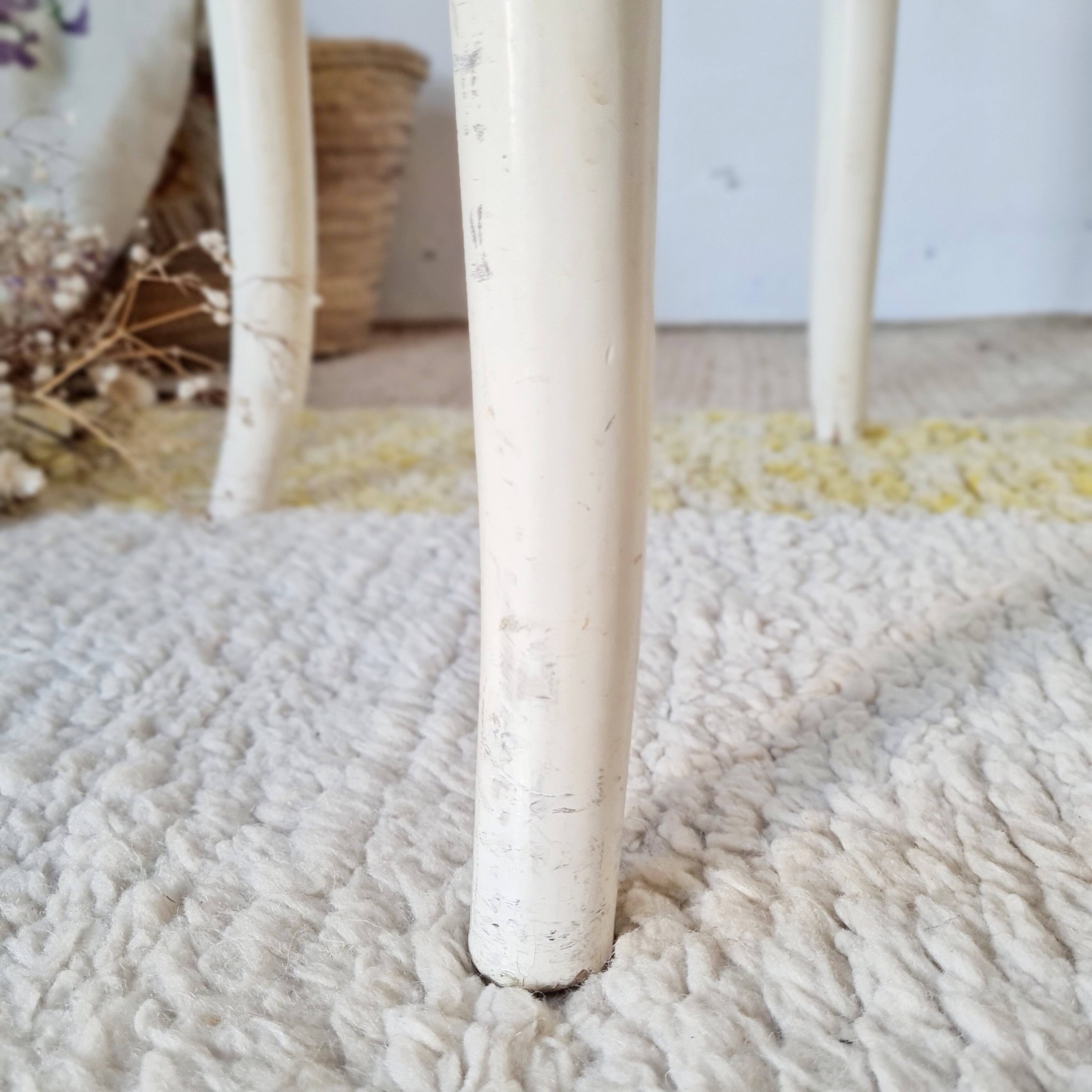 Antique stool with a wooden frame and a cream and green striped fabric seat.