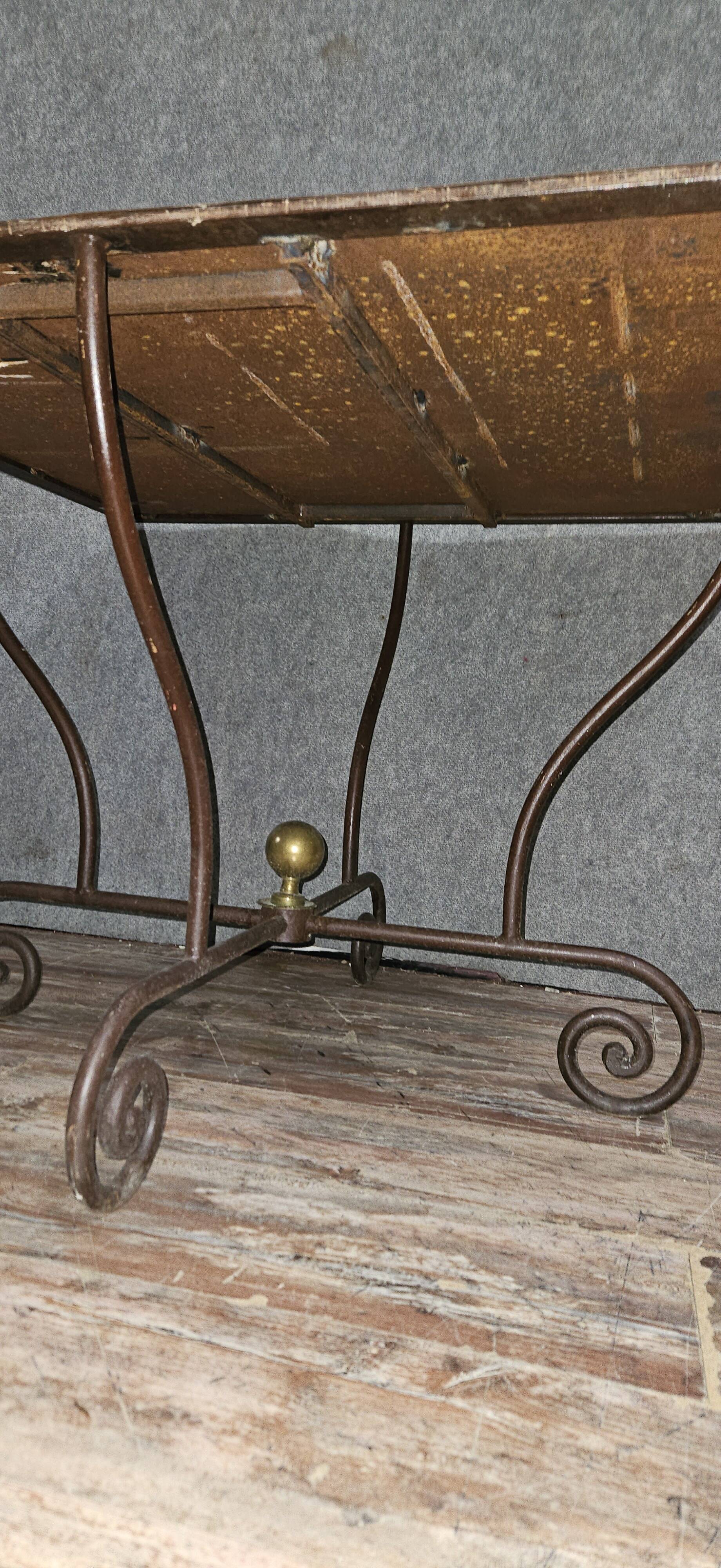 Table en fer forgé à piétement sculptural, ornée de volutes