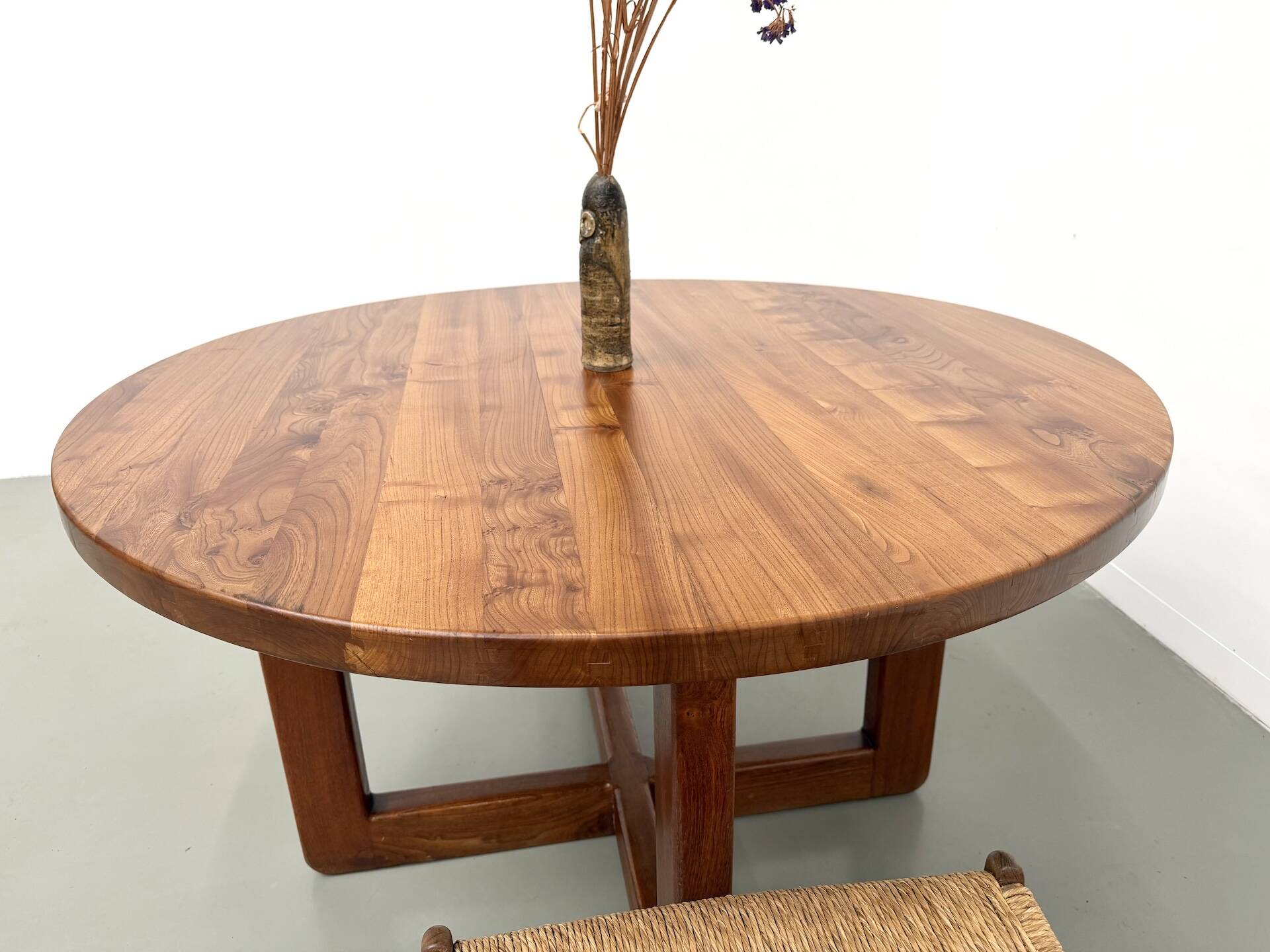 Modernist round table in solid elm, crossed legs.