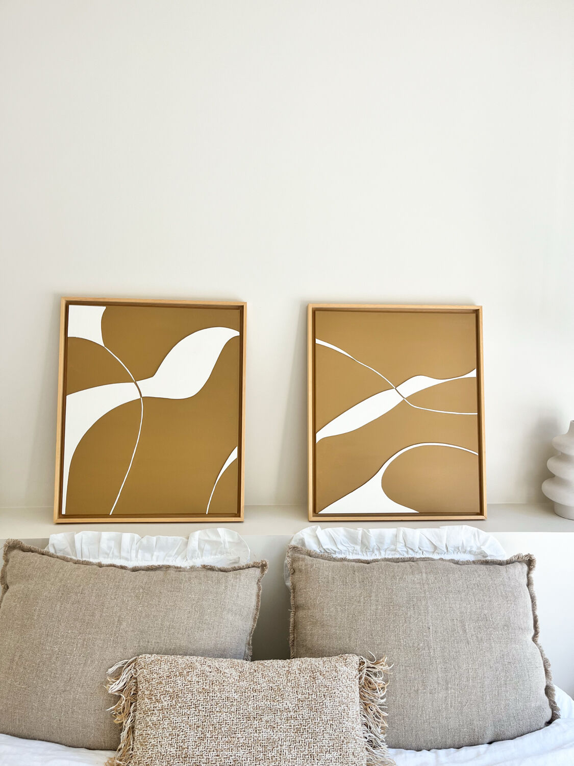 Diptych relief panels with a brown camel and cream background.