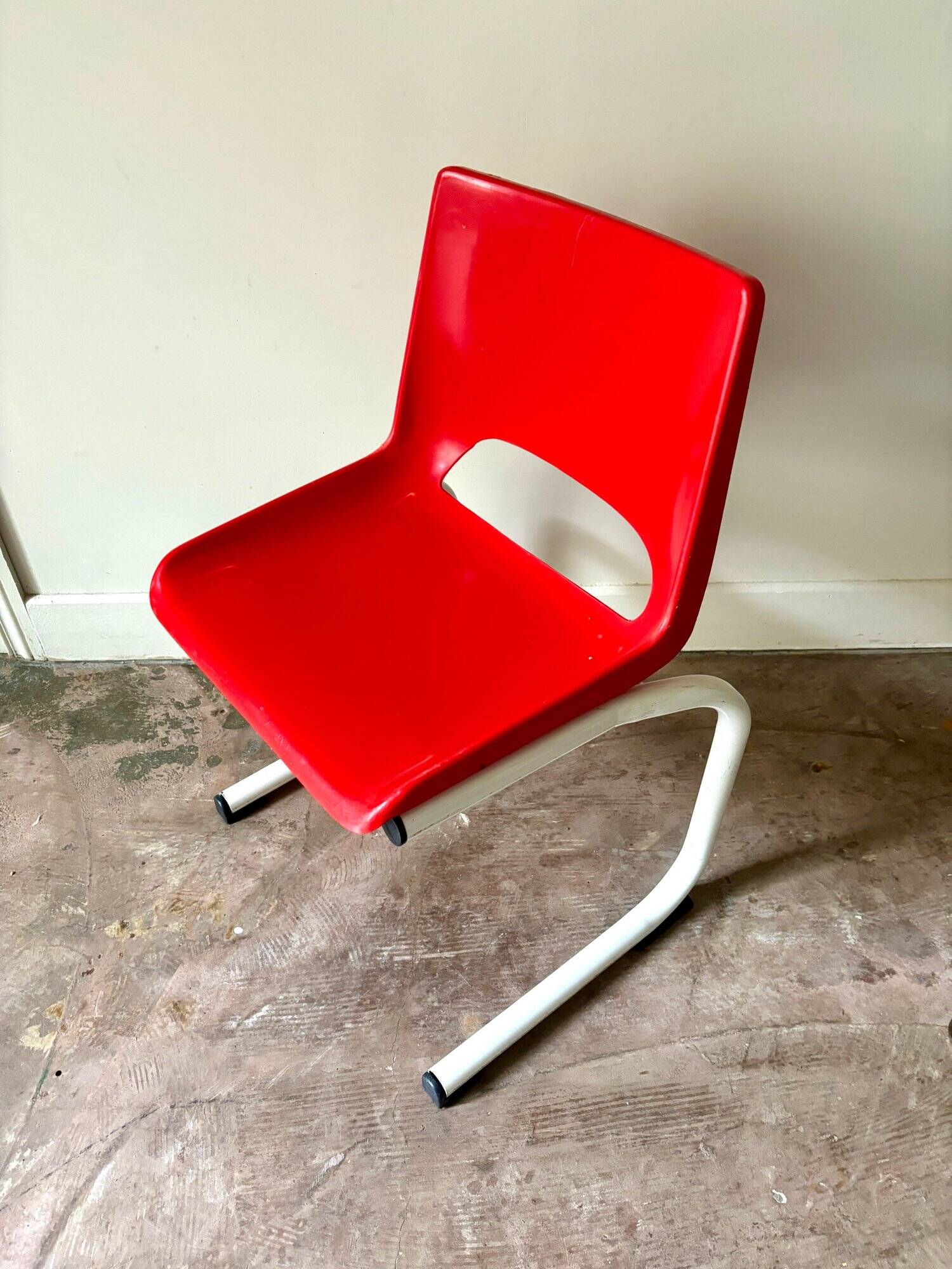 Children's chair in white metal and red plastic