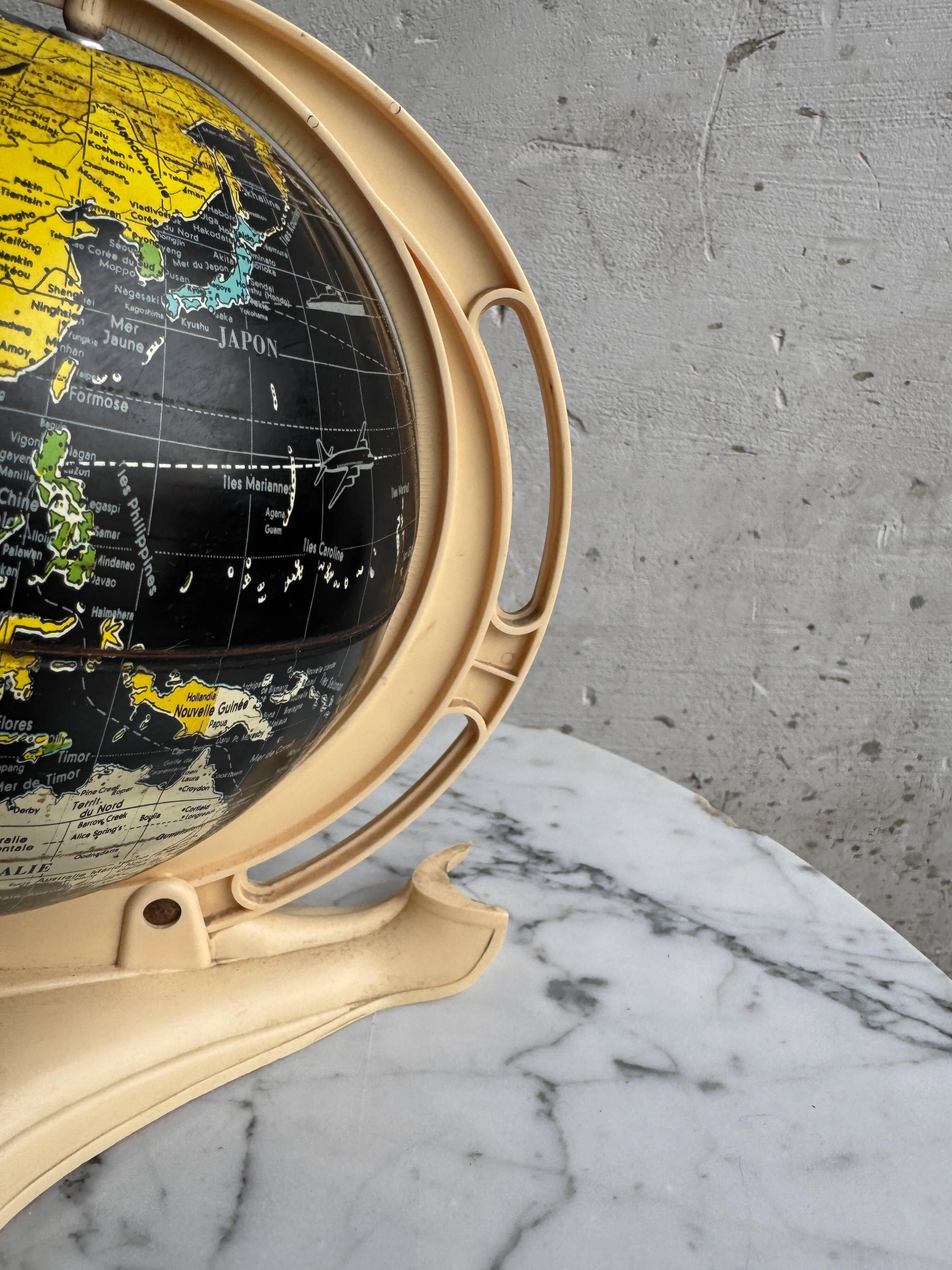 French mid-century school globe with black oceans on printed paper, cream plastic base