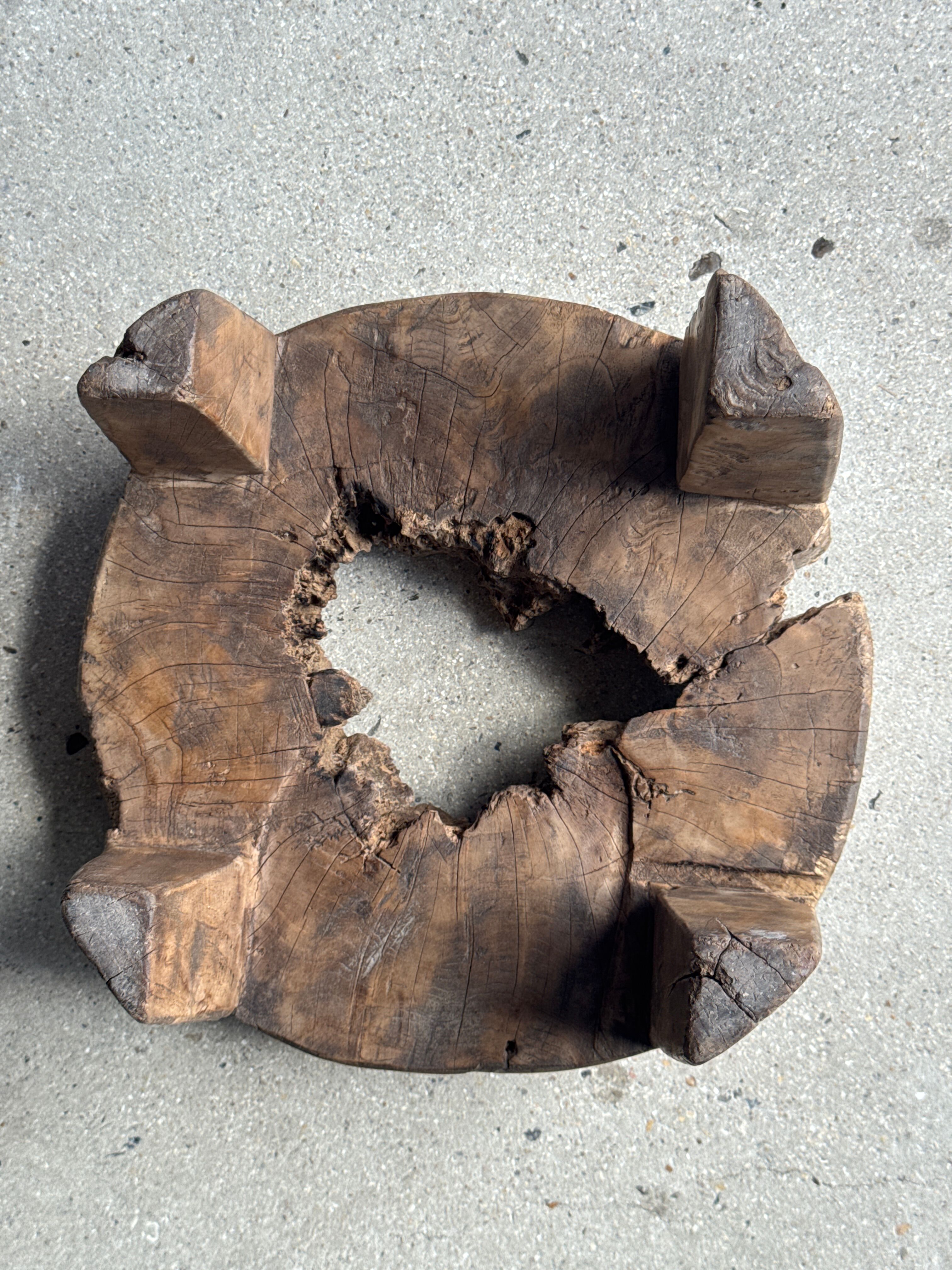 Small low circular four-legged stool in organic old teak with cut-out design H2