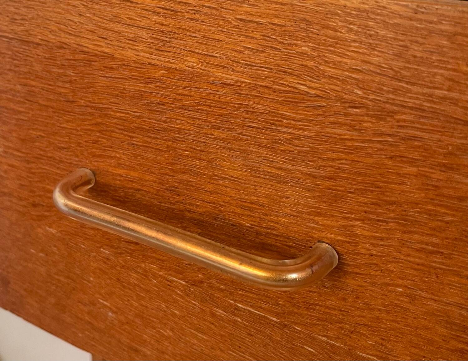 Vintage 1960s chest of drawers with covered handles.