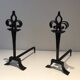 Important pair of wrought iron andirons with torch in heraldic fleur-de-lis design.