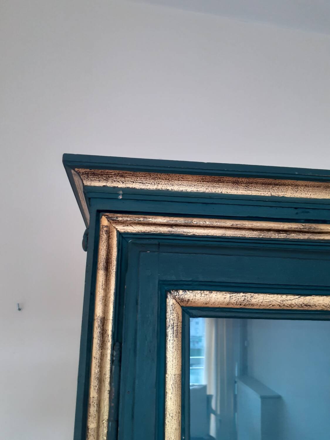 Glass-fronted cabinet in weathered green wood