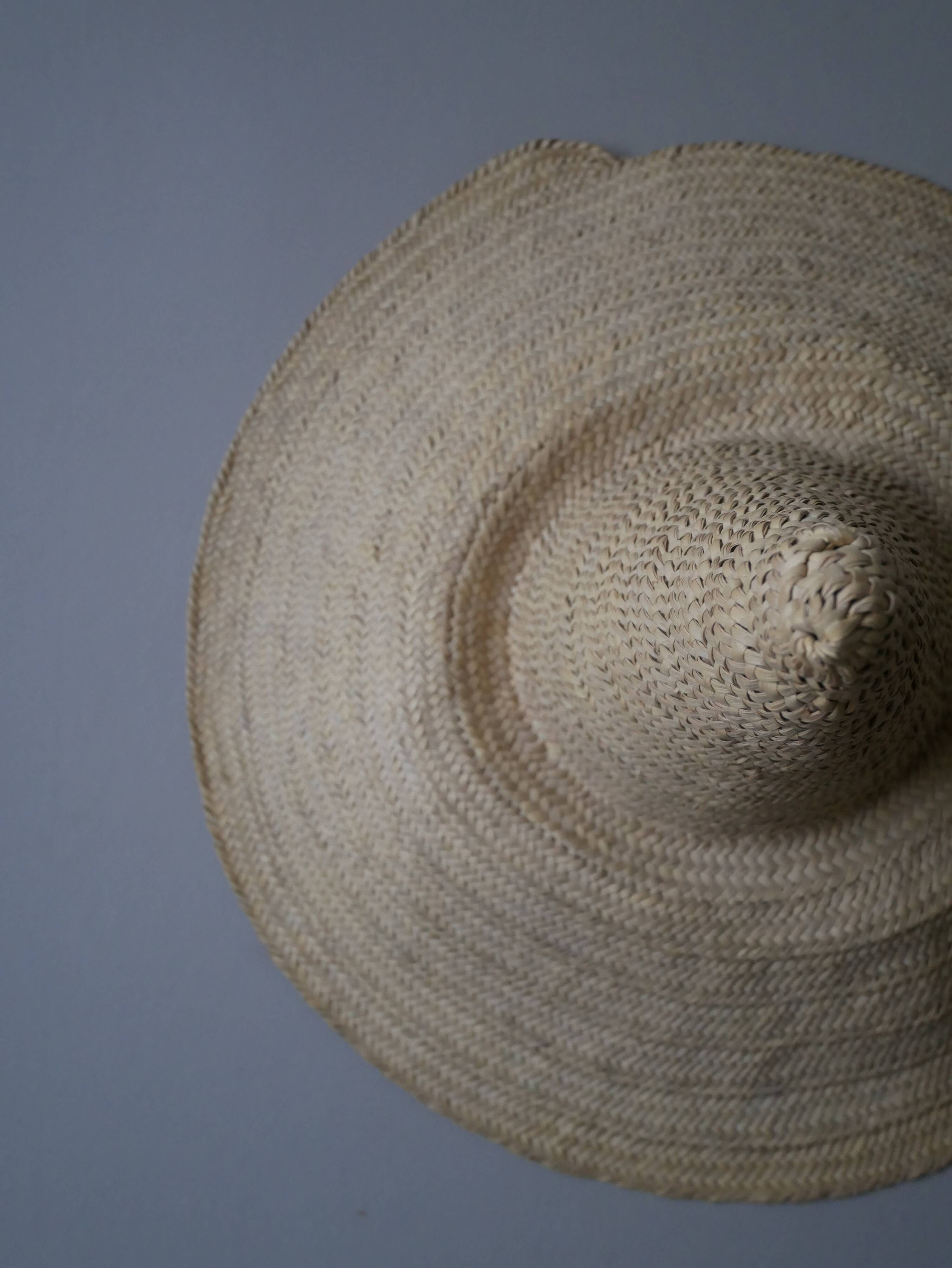 Hand-woven wicker straw hat, artisanal production, decorative object, bohemian ethnic countryside