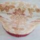 Beige toad armchair with floral patterns and red fringes