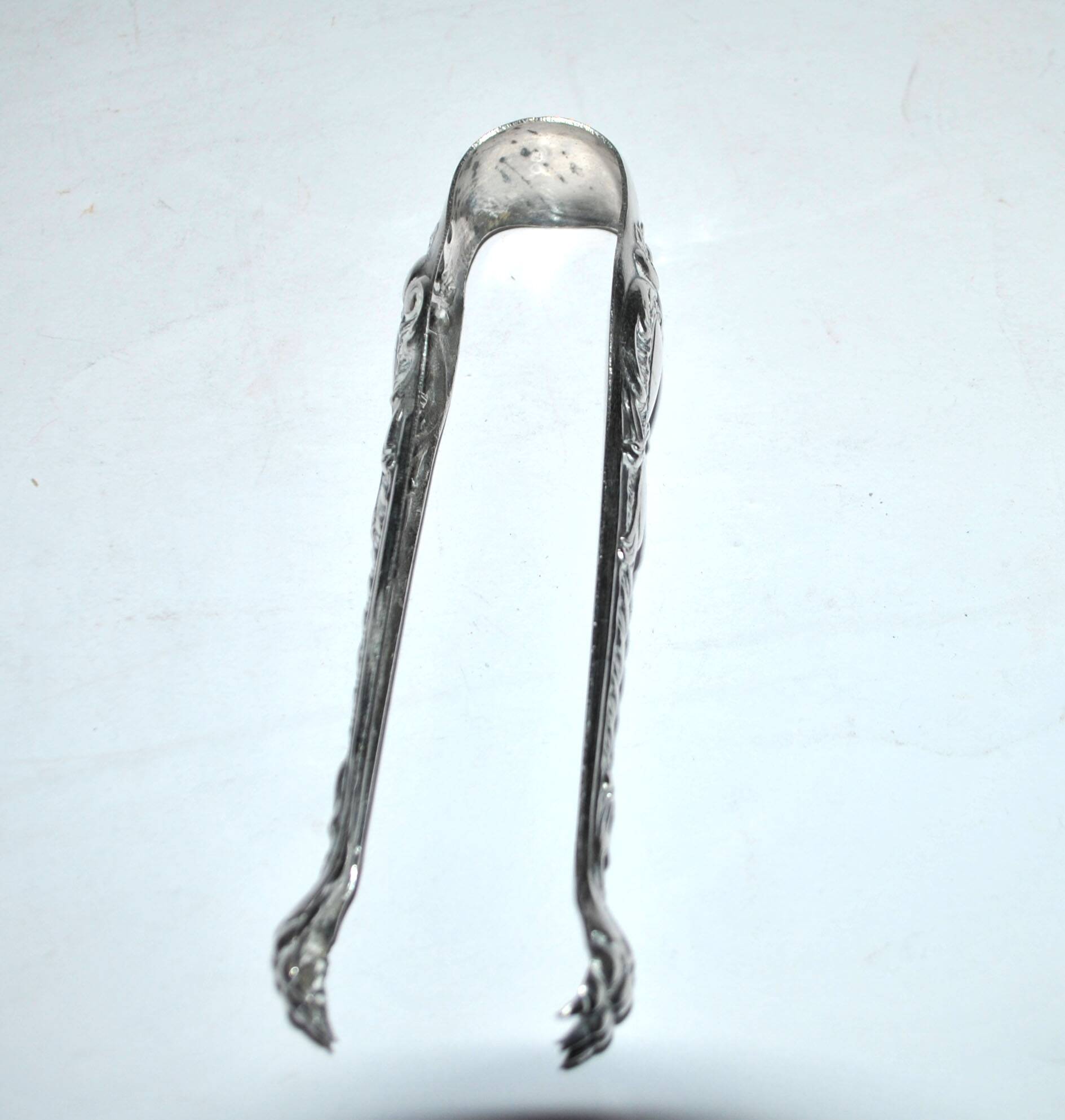 Rocaille sugar tongs in silver metal with lion claw medallion