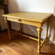 Desk table from the late 19th century, painted mustard, with turned stretcher.