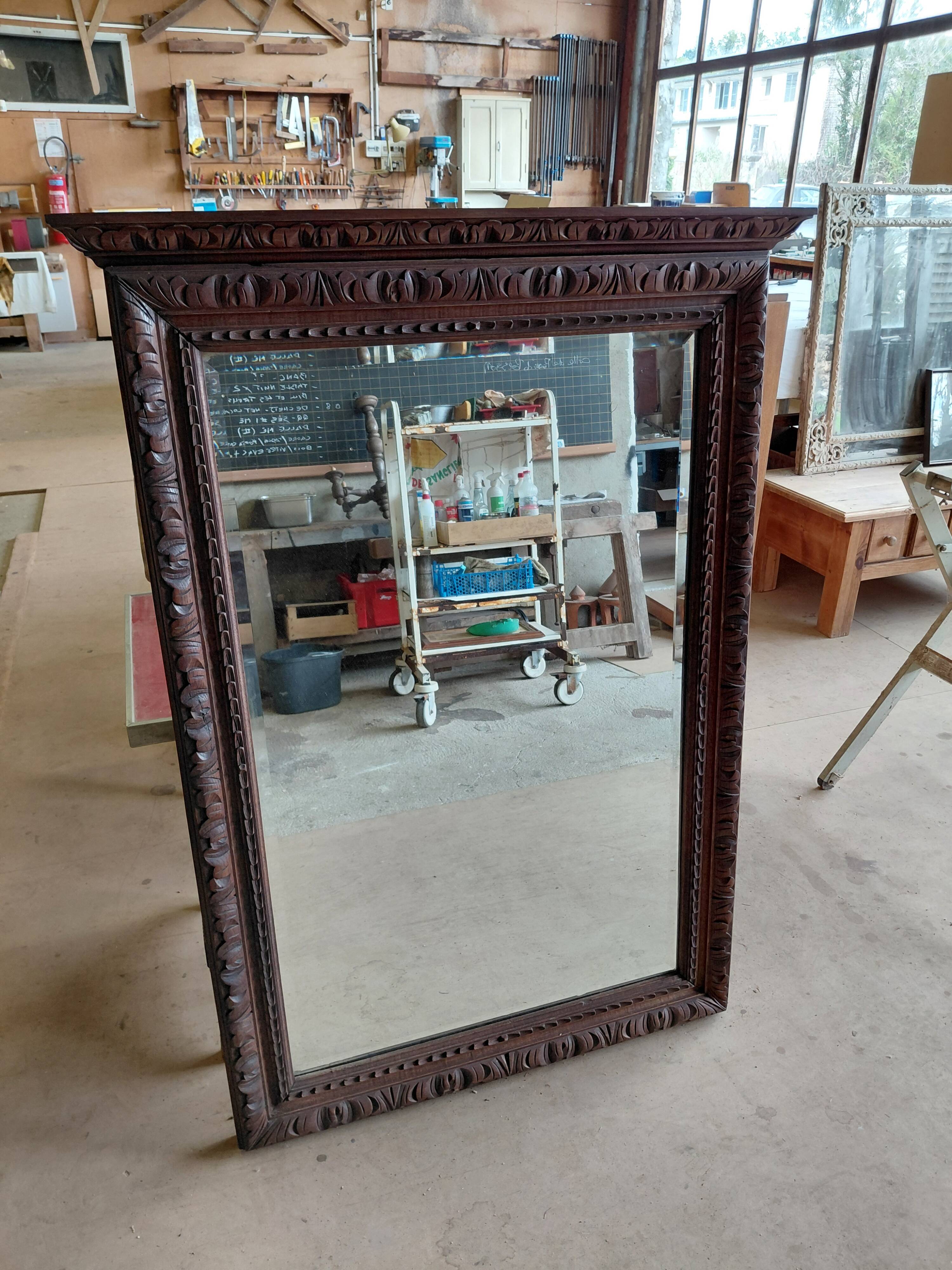 Large bevelled mirror with a carved wooden frame