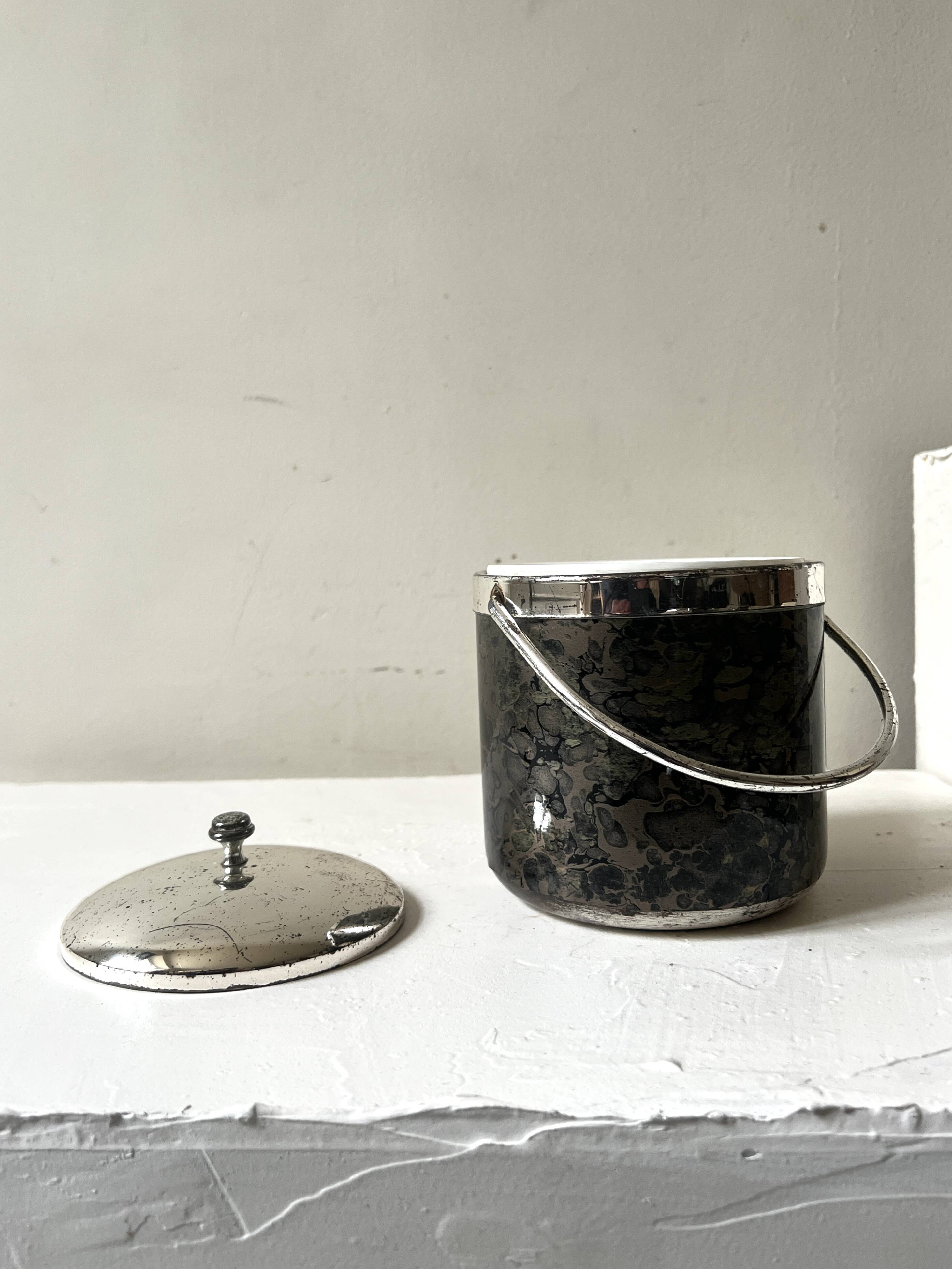 Vintage chrome metal ice bucket with black marbled design, 1970s style.