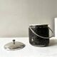 Vintage chrome metal ice bucket with black marbled design, 1970s style.