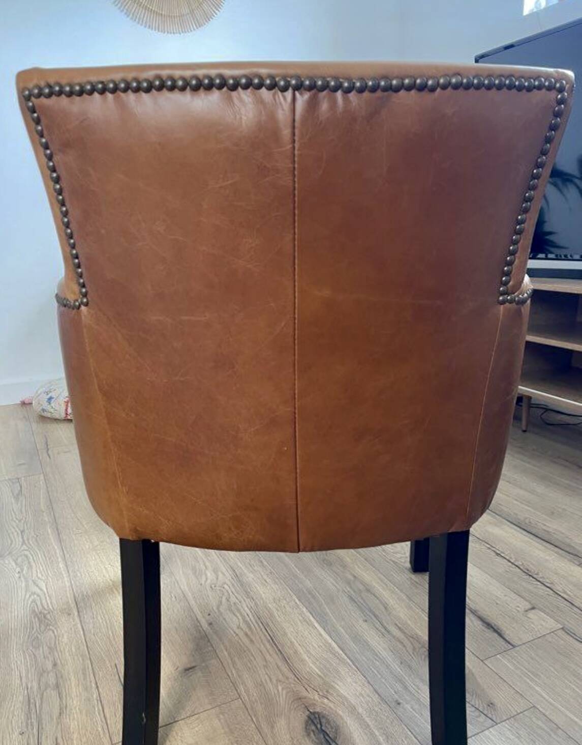 Chair with armrests in aged brown cowhide leather