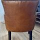 Chair with armrests in aged brown cowhide leather