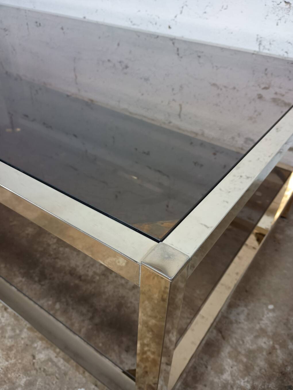 1970s coffee table in brass with a double smoked glass top.