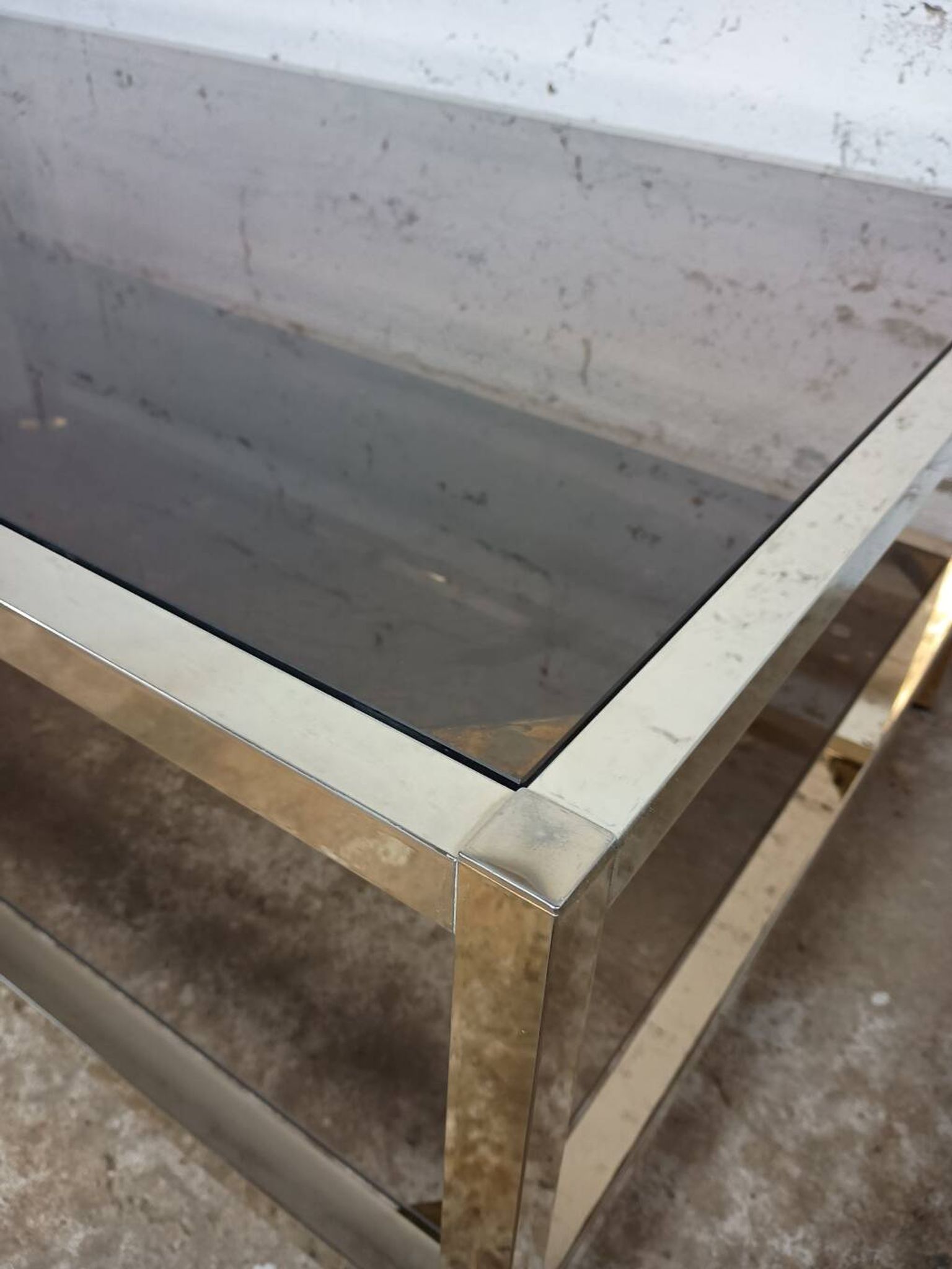 1970s coffee table in brass with a double smoked glass top.