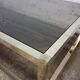 1970s coffee table in brass with a double smoked glass top.