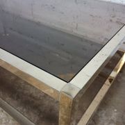 1970s coffee table in brass with a double smoked glass top.