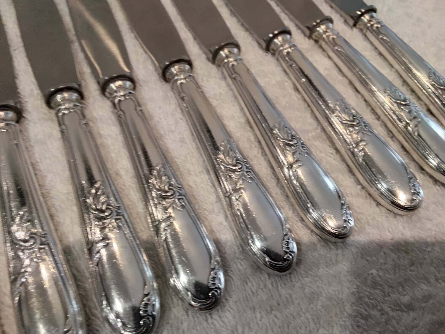 12 silver-plated metal dessert knives with rocaille ribbon decoration, 21.4 cm