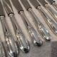 12 silver-plated metal dessert knives with rocaille ribbon decoration, 21.4 cm