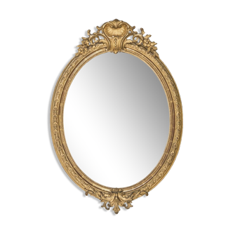 Miroir ovale 19ème en bois doré avec cimier coquille