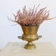 Vintage brass cache-pot on a stand with handles, classic decor.