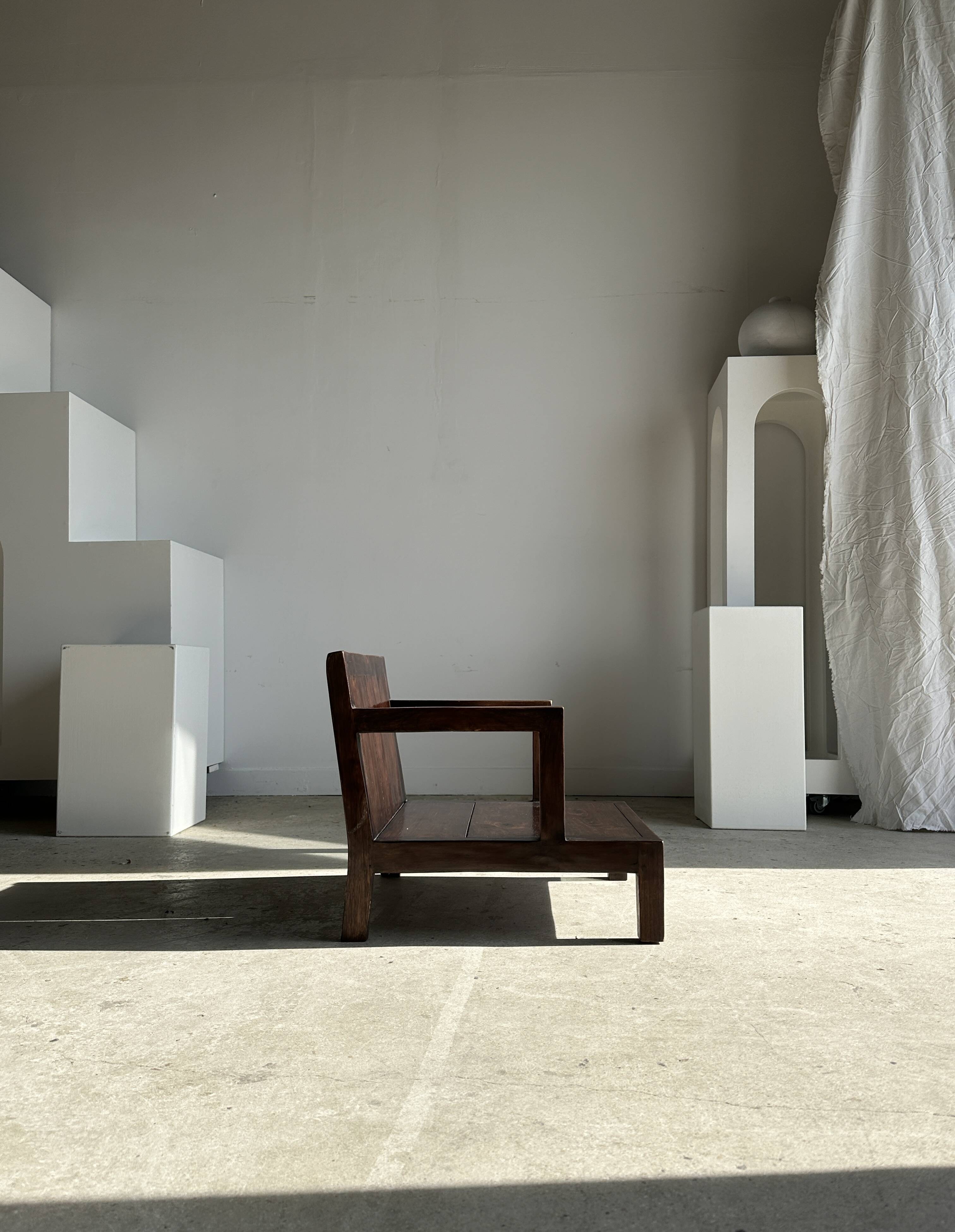 Small low armchair in varnished brown wood