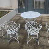 Folding round table and four wrought iron armchairs