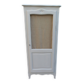 Vintage beige wardrobe made of wood and jute fabric.