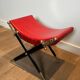 Neoclassical curule stool in red leather, decorated with crossed swords in bronze and metal covered in black leather.