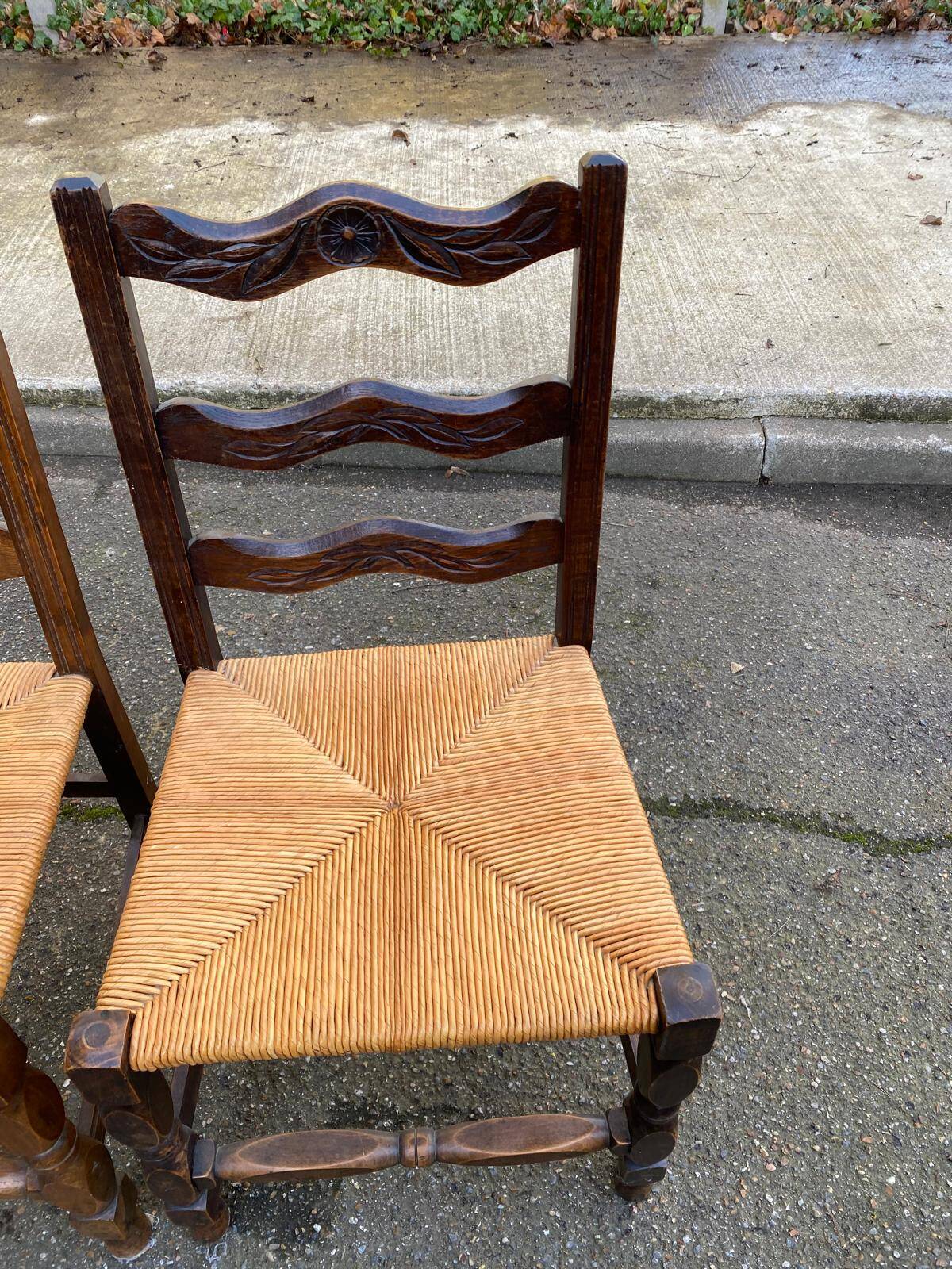 2 solid wood chairs with carved rush seats