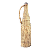 Bouteille en verre ambré dans son panier à poignée en osier