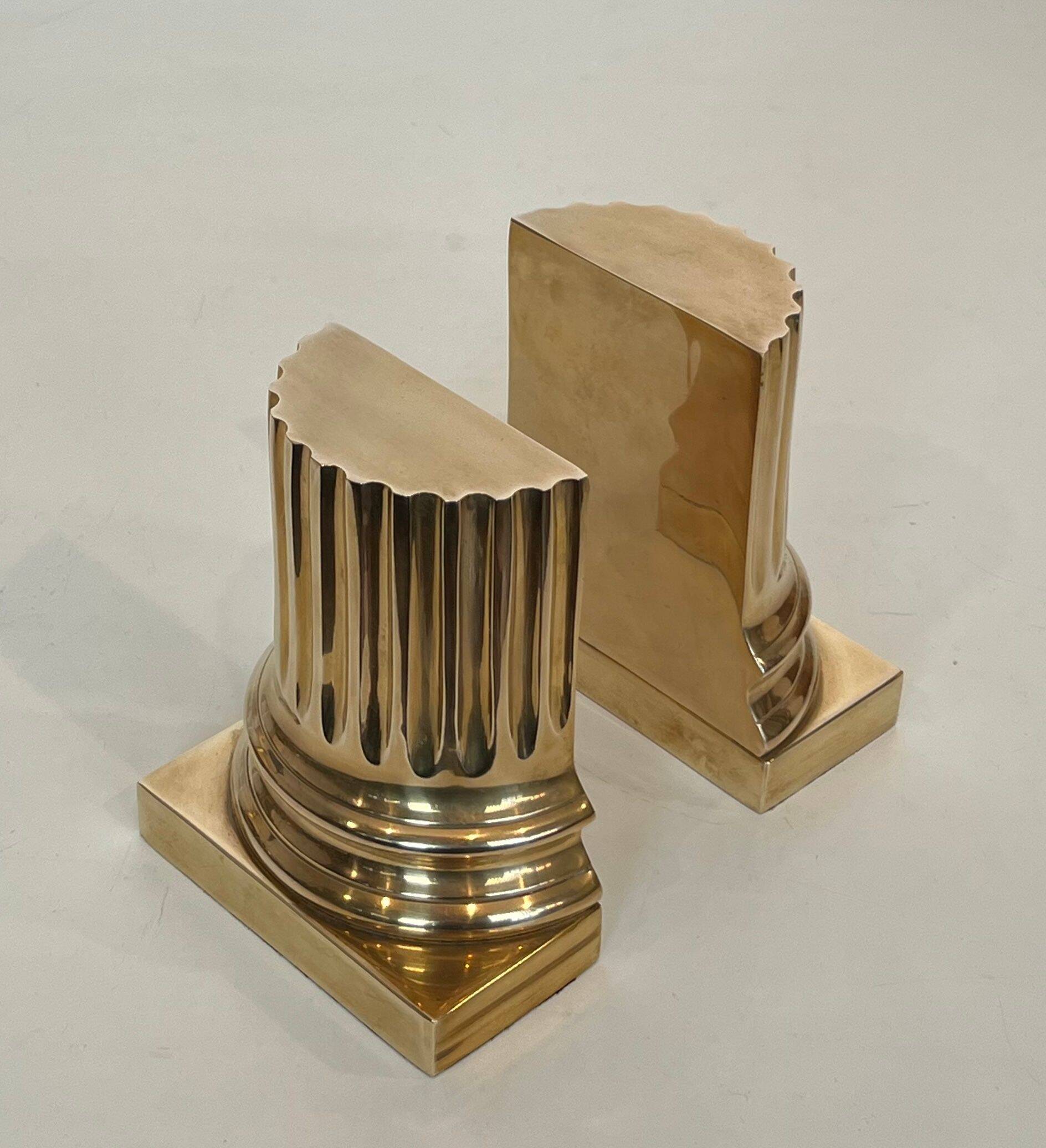 A pair of brass bookends representing columns.