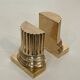 A pair of brass bookends representing columns.