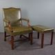 Elegant armchair and footrest in English green leather