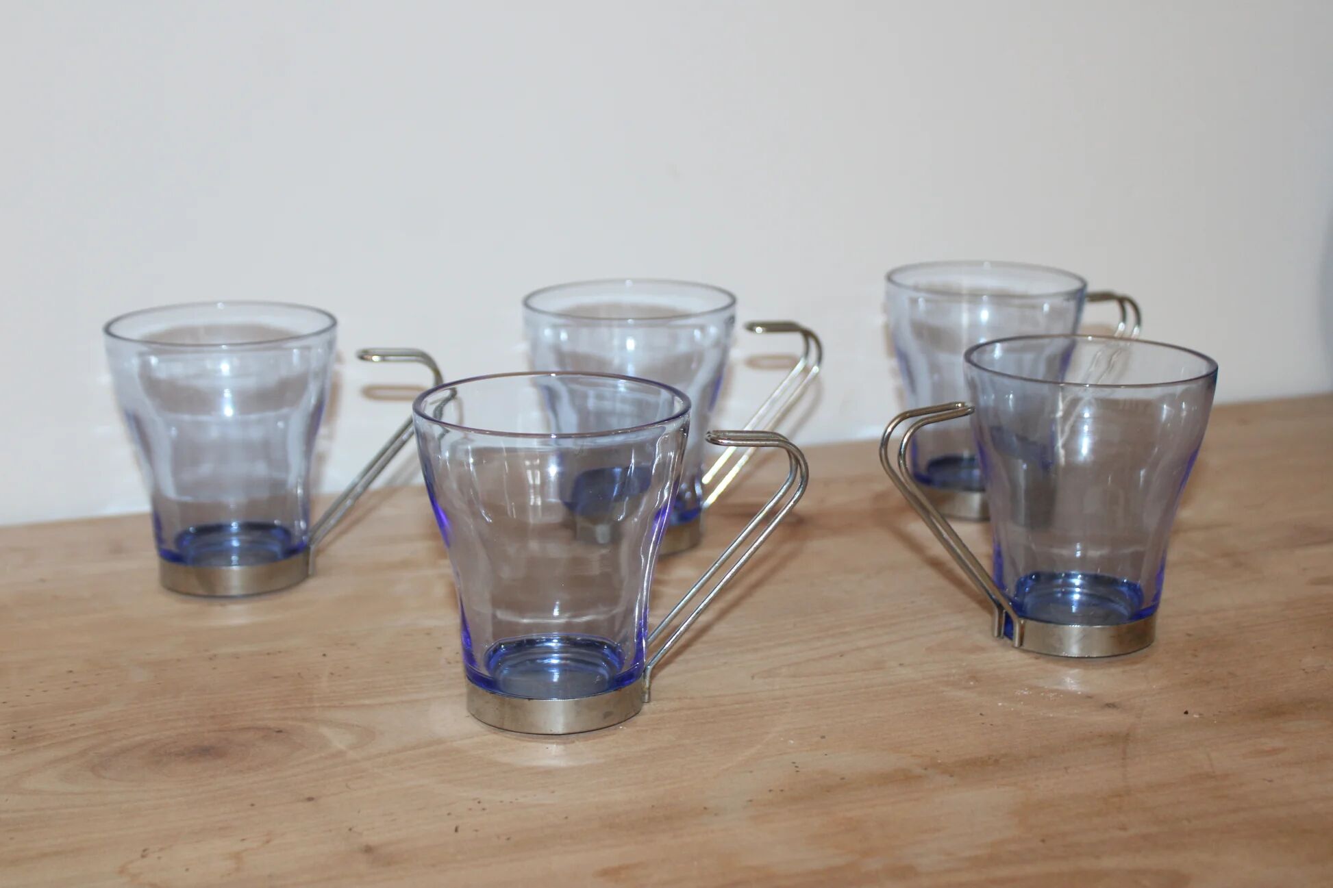 Set of 5 vintage blue-tinted glass cups with metal holders.