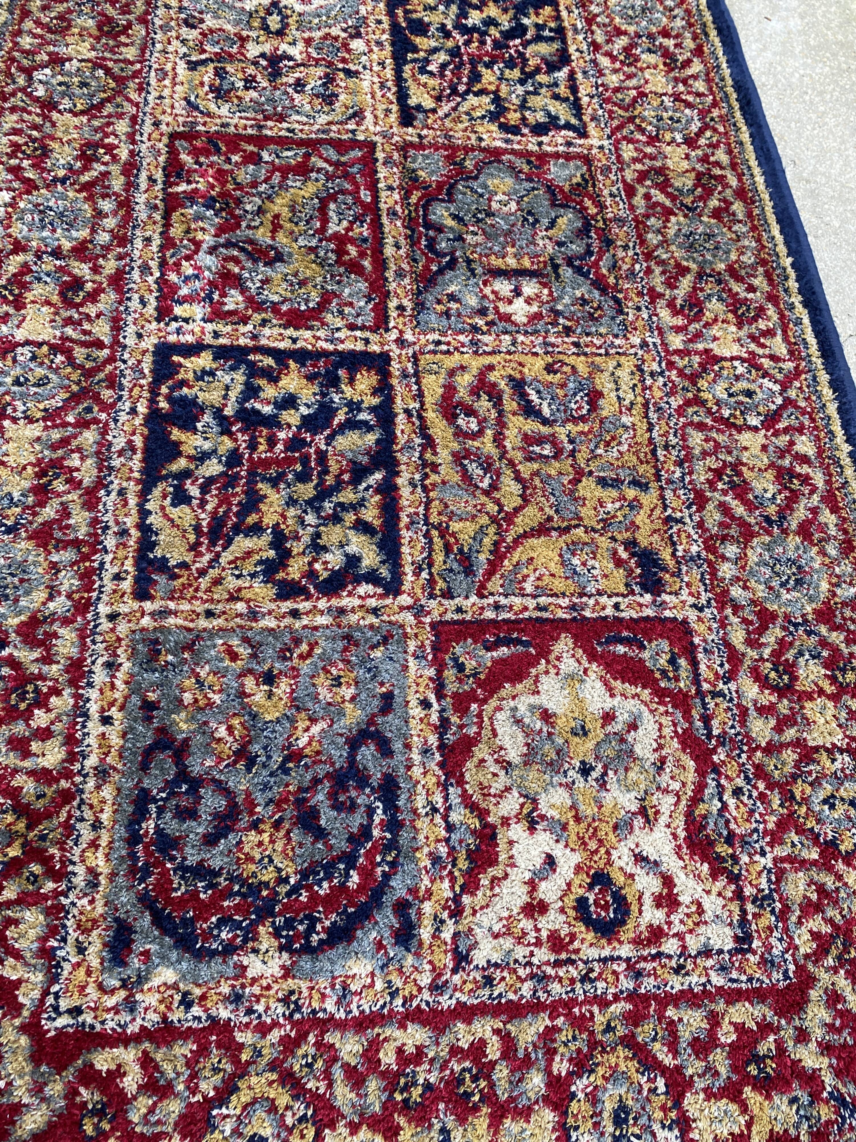 Vintage mechanical Turkish rug with box decoration on a red and navy blue background 139 x 68 cm