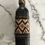 Ethnic decorative bottle in leather and raffia braiding