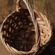 Round woven dark wicker basket with openwork vintage handle