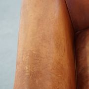 Cognac-colored cow leather club chair finished with decorative nails in English style