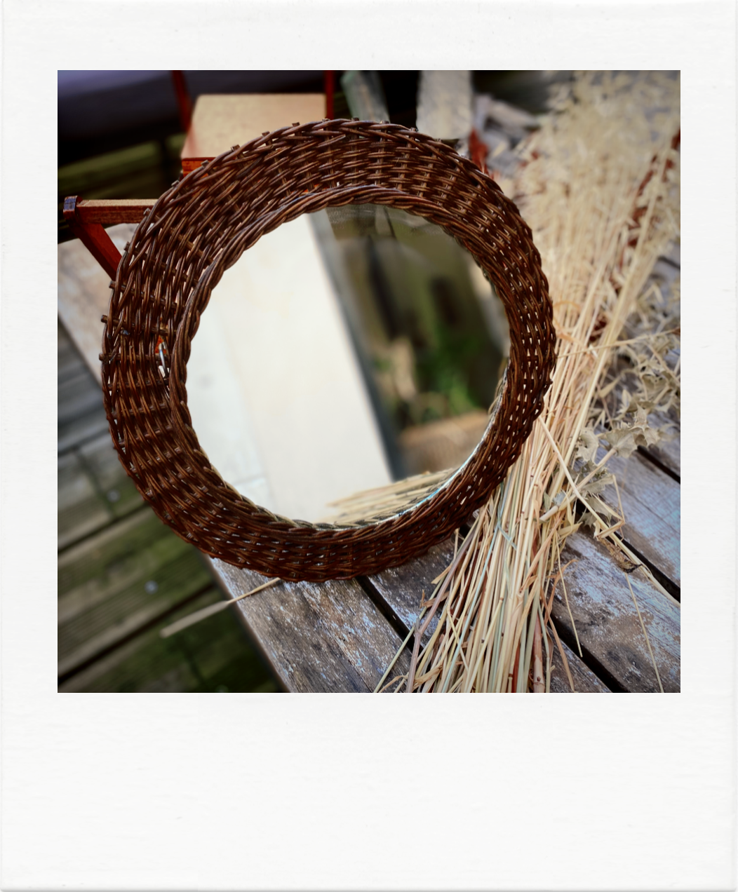 Round mirror in dark rattan