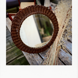 Round mirror in dark rattan