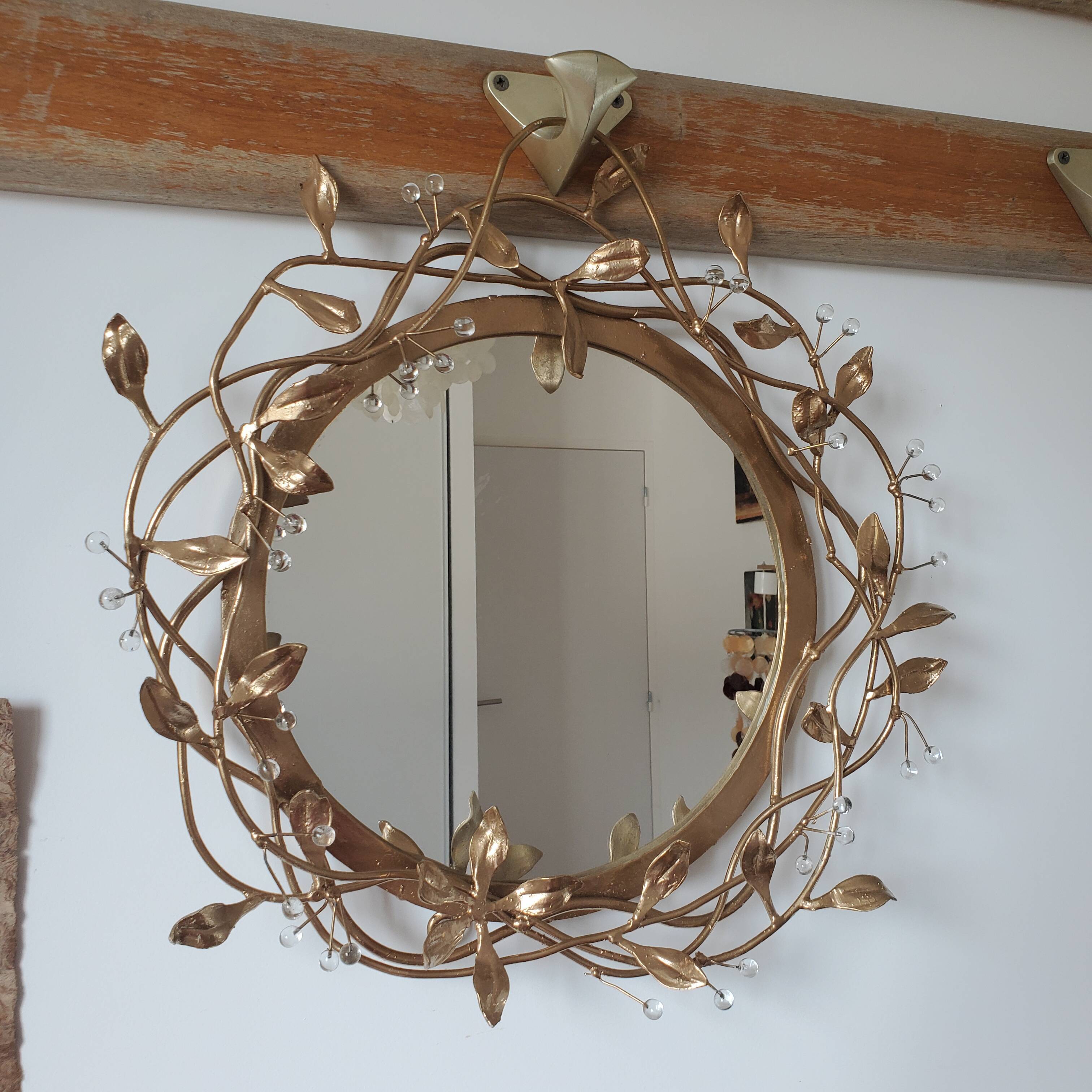 Round mirror in gilded wrought iron and leaves