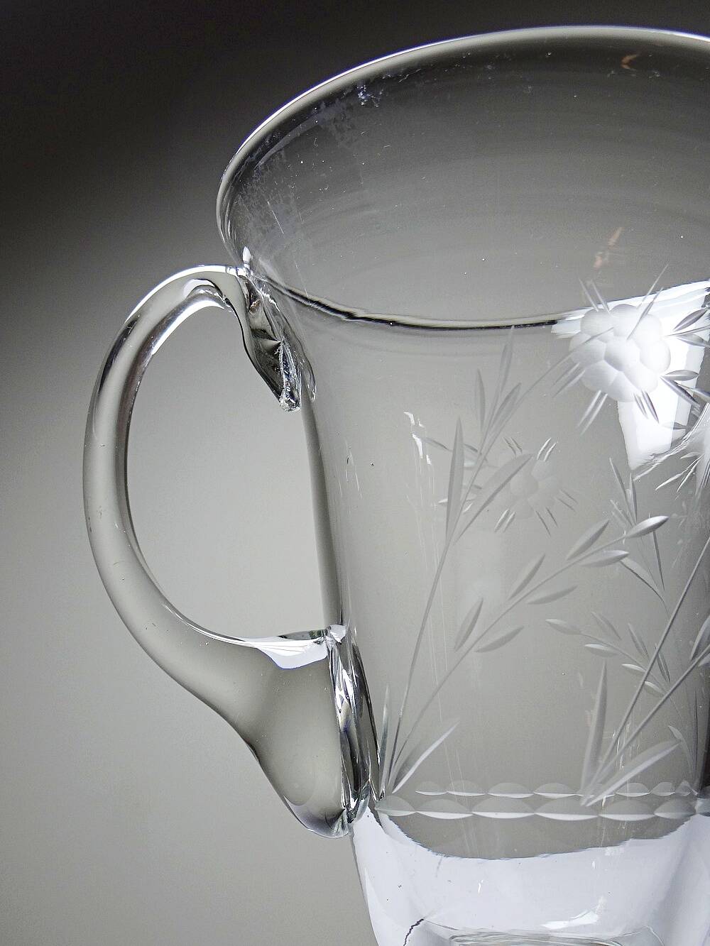Antique glass pitcher with wheel engraving and floral decoration, Bohemia, early 20th century.